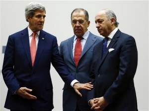 US Secretary of State Kerry gestures towards French Foreign Minister Laurent Fabius during a ceremony at the United Nations in Geneva